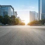 Empty city road flanked by tall buildings, symbolizing a hub for lawyers and real estate transactions.