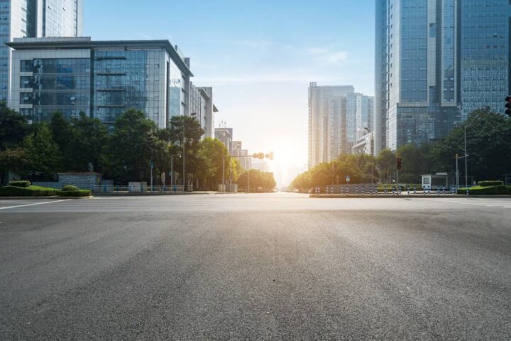 Empty city road flanked by tall buildings, symbolizing a hub for lawyers and real estate transactions.